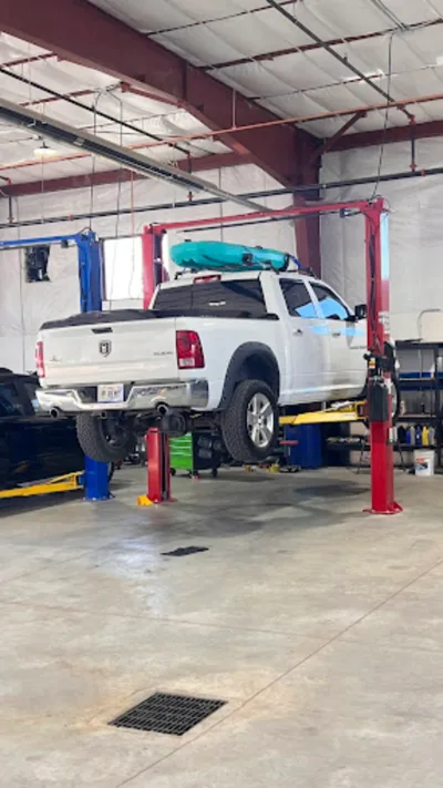 Truck repair service at Ethan’s Honest Automotive with technician inspecting and servicing a work truck