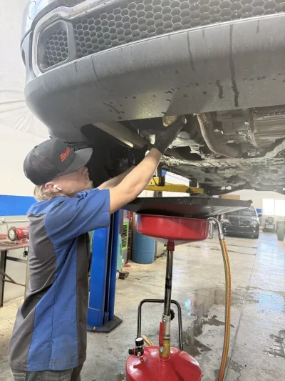 Technician performing an oil change service using fresh engine oil and filter at Ethan’s Honest Automotive